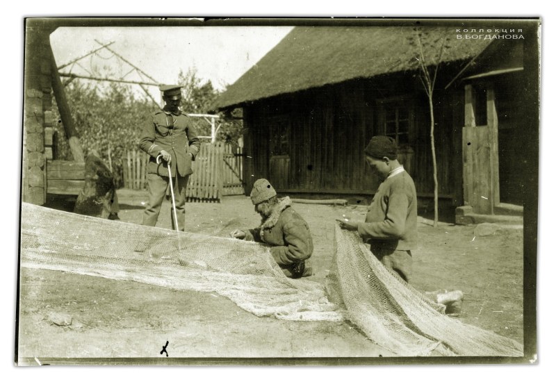Рыбаки чинят сети в деревне Бояры у озера Большие Швакшты. Июнь 1916 г.